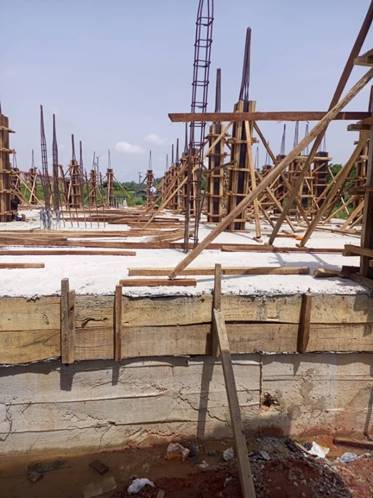 A construction site with wooden beams and a crane
Description automatically generated